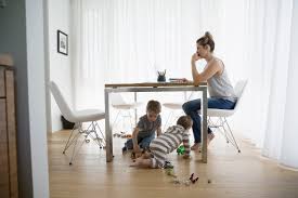 Vrouw met jonge kinderen aan keukentafel — werk en privé combineren als dertiger